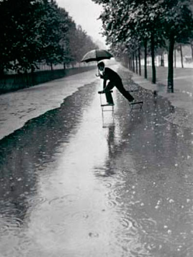 Man crossing puddle on chairs, 1934