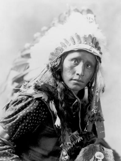 Indian wearing White War Bonnet, 1900